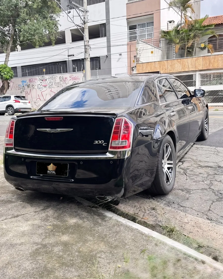 Chrysler 300C preto visto de traseira em três quartos